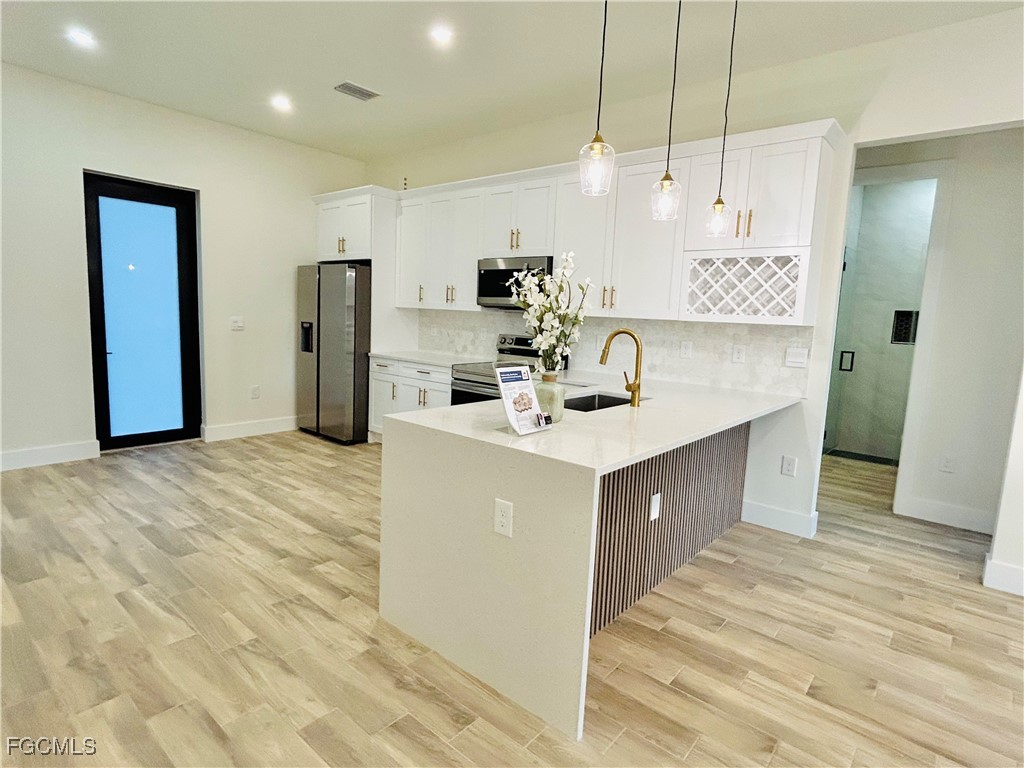 3804 6th Street Southwest Lehigh Acres, FL 33976 - Photo 9 of 45 a kitchen with kitchen island a sink stainless steel appliances and counter space
