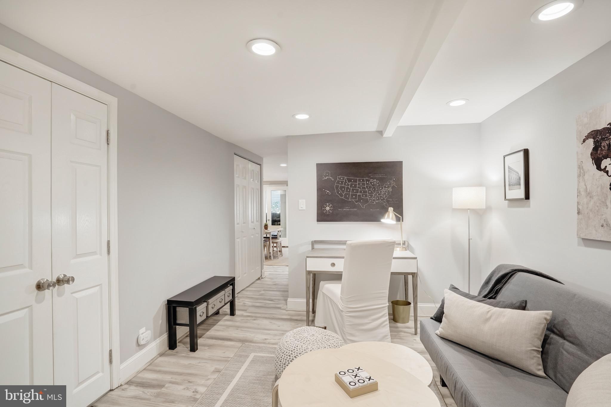 3817 Cathedral Avenue Northwest, Unit GARDEN Washington, DC 20016 - Photo 17 of 33 a living room with furniture a mirror and a painting on the wall