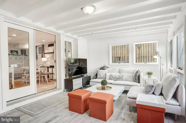 a living room with furniture a flat screen tv and large window