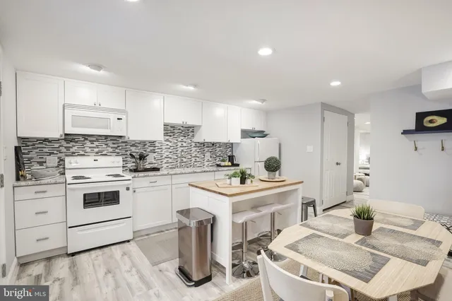 a kitchen with granite countertop sink stove top oven and cabinets