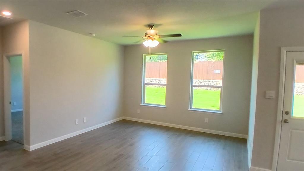 312 Logan Street Keene, TX 76059 - Photo 3 of 15 a view of an empty room with a window and wooden floor