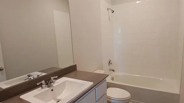 a view of an empty room with closet and a window