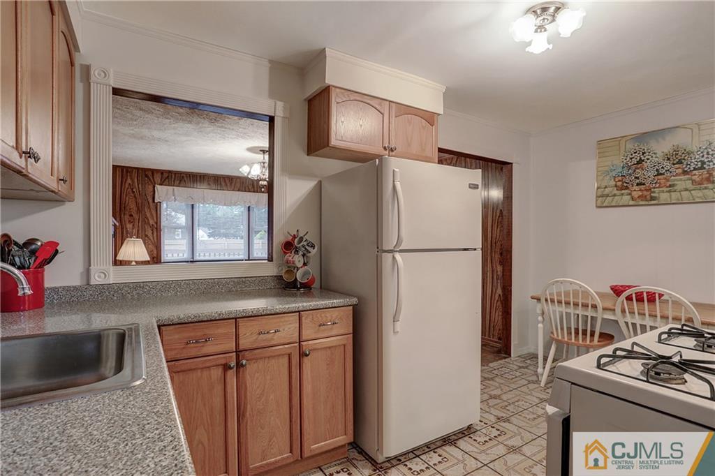 4 Channing Road East Brunswick, NJ 08816 - Photo 9 of 21 a kitchen with stainless steel appliances granite countertop a refrigerator a stove and a sink with wooden floor