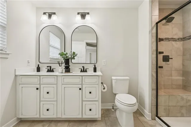 a bathroom with a double vanity sink mirror and toilet