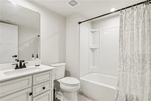 a bathroom with a sink a toilet a mirror a bathtub and shower