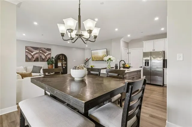 a kitchen with stainless steel appliances a table chairs and cabinets