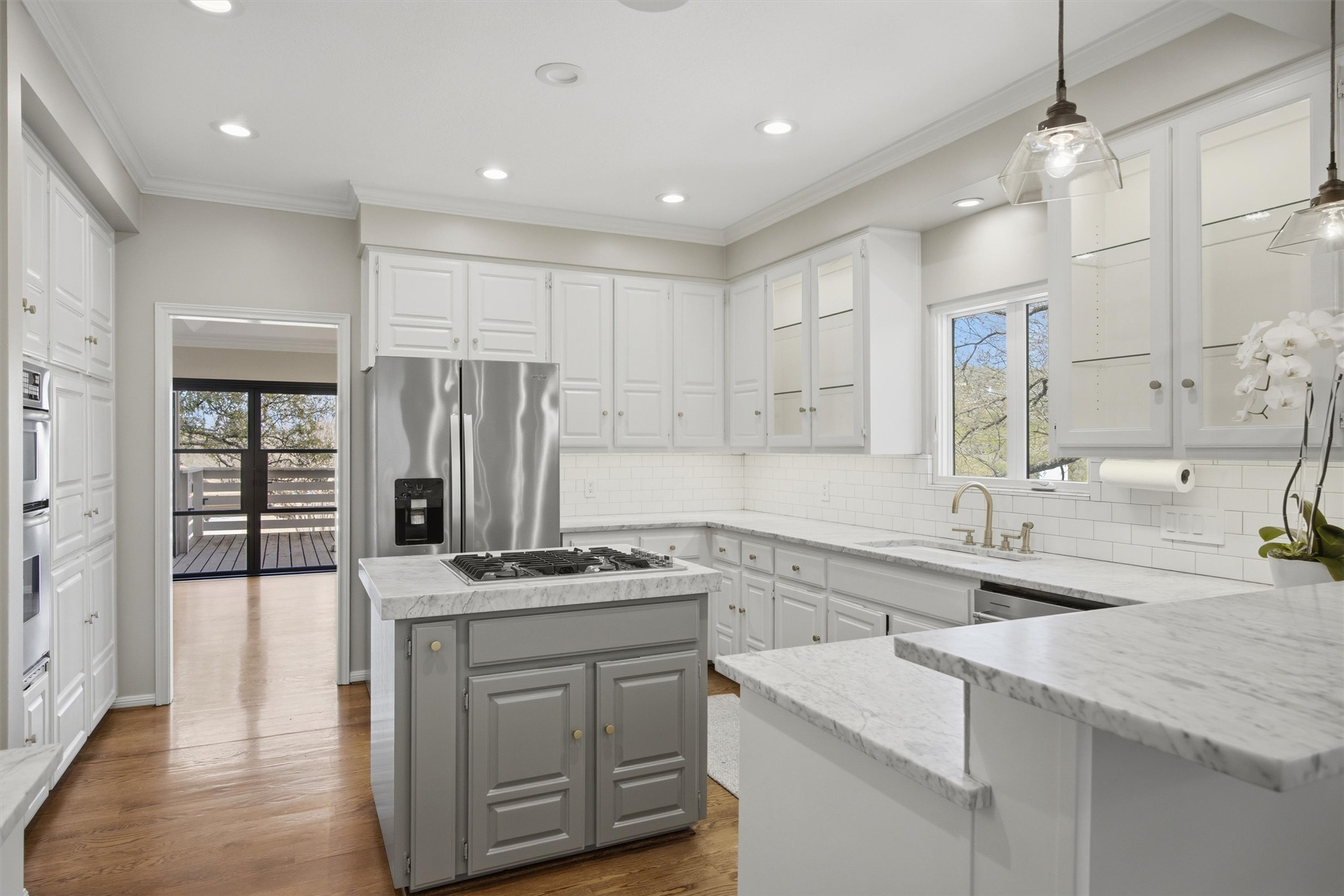 5705 Carry Back Lane Austin, TX 78746 - Photo 15 of 39 a kitchen that has a sink a center island stainless steel appliances and cabinets