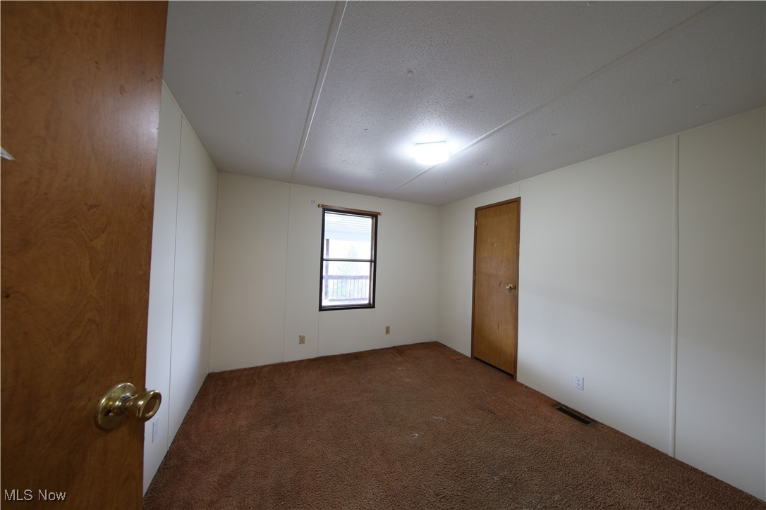 406 Avalon Road Southwest Dellroy, OH 44620 - Photo 20 of 36 Unfurnished room featuring carpet flooring and a textured ceiling