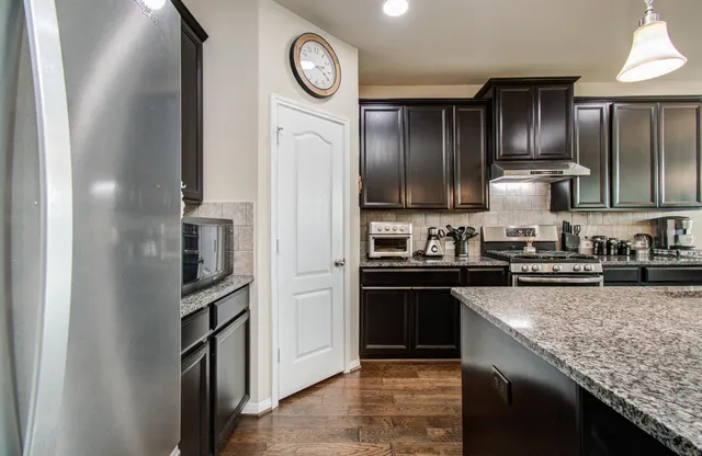 a kitchen with granite countertop stainless steel appliances and wooden cabinets