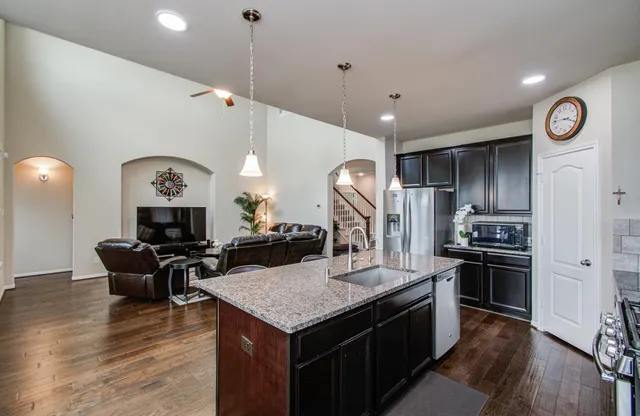 a kitchen with a stove a refrigerator and chairs