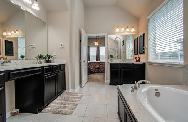 a bathroom with a tub sink and mirror