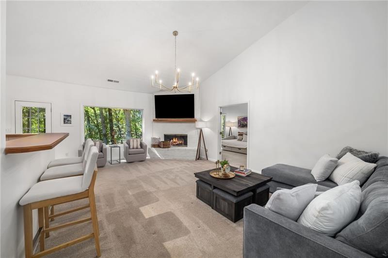 16218 Henderson Road Milton, GA 30004 - Photo 13 of 81 a living room with furniture a chandelier and a flat screen tv