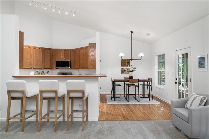 16218 Henderson Road Milton, GA 30004 - Photo 19 of 81 a living room with stainless steel appliances kitchen island granite countertop furniture and a wooden floor
