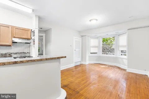 a view of kitchen with granite countertop cabinets and window