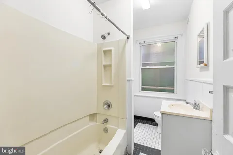 a bathroom with a tub sink and mirror