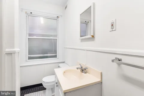 a bathroom with a sink toilet and mirror