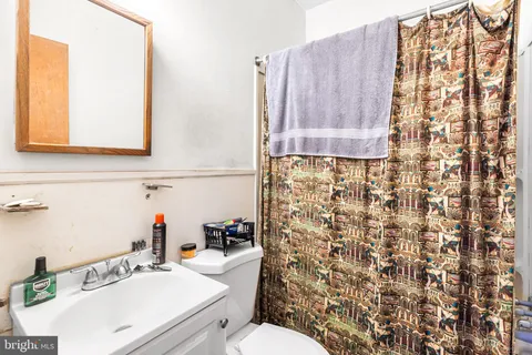 a bathroom with a sink a toilet and shower curtain