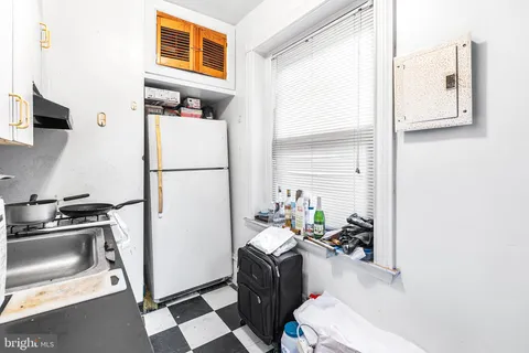 a kitchen with a refrigerator and a stove top oven