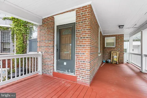 a view of a porch with wooden floor and a yard