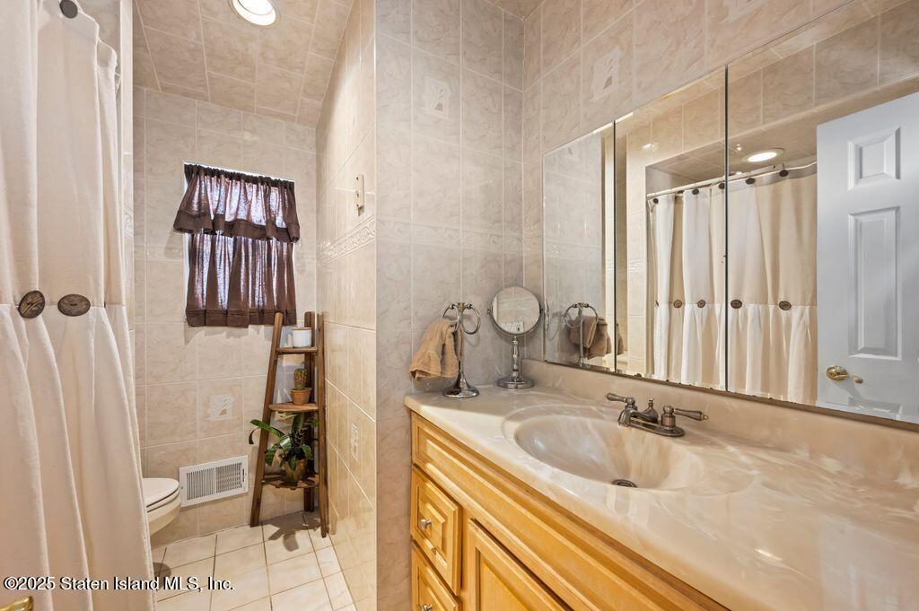 53 Plymouth Road Staten Island, NY 10314 - Photo 13 of 23 a bathroom with a sink double vanity and a mirror