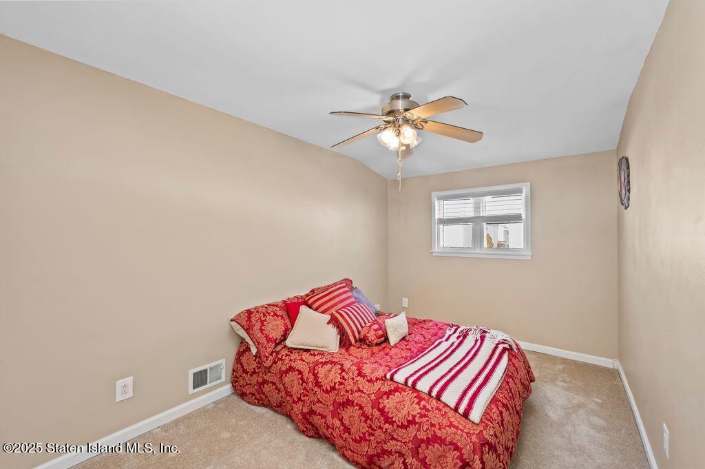 53 Plymouth Road Staten Island, NY 10314 - Photo 14 of 23 a bedroom with a bed and a chandelier