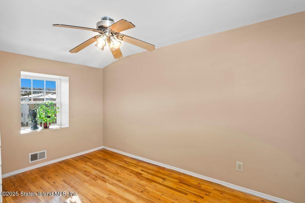 53 Plymouth Road Staten Island, NY 10314 - Photo 16 of 23 a view of an empty room with wooden floor and a window