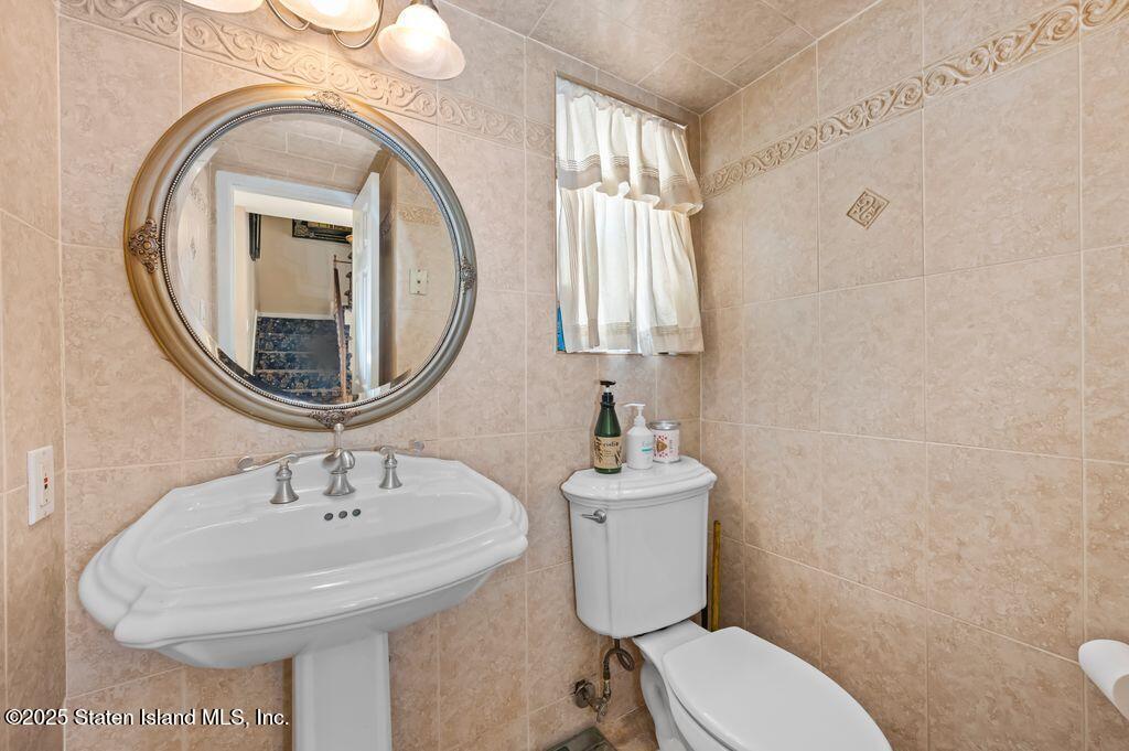 53 Plymouth Road Staten Island, NY 10314 - Photo 6 of 23 a bathroom with a toilet sink and mirror