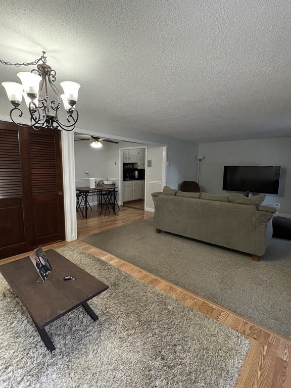 1186 Worcester Road, Unit 611 Framingham, MA 01702 - Photo 3 of 14 a living room with furniture and a chandelier