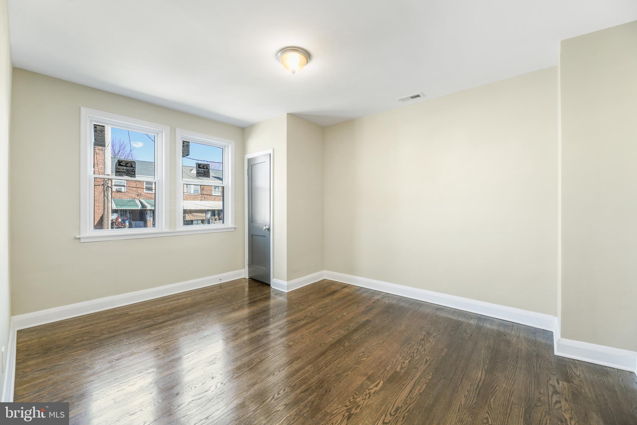 1410 Kingsway Road Baltimore, MD 21218 - Photo 14 of 24 an empty room with wooden floor and windows
