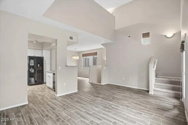 a view of an empty room with wooden floor and a cabinet