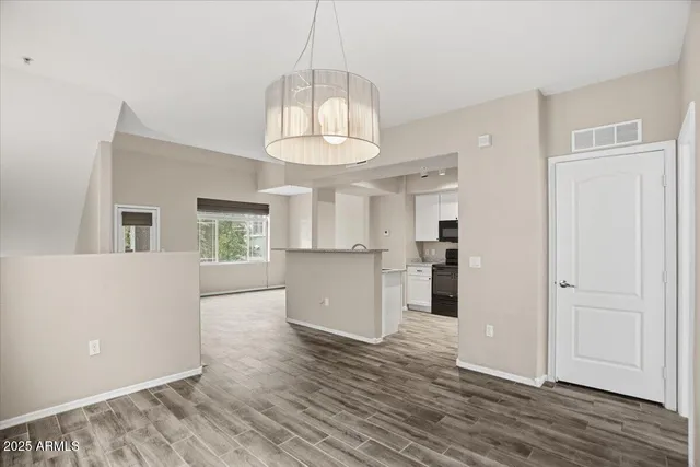 a view of a kitchen with wooden floor and a window