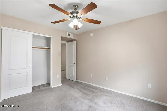 an empty room with a ceiling fan and a window