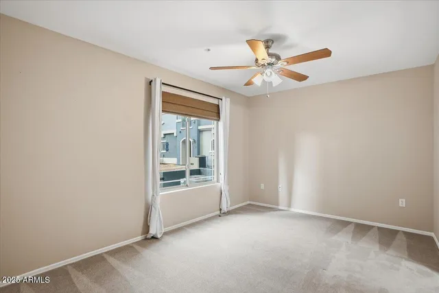 an empty room with chandelier fan