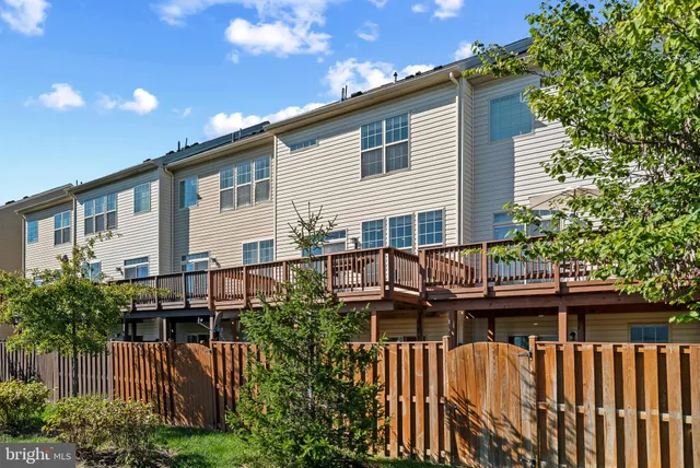a view of a house with wooden deck and furniture