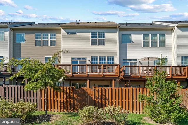 a view of a house with wooden deck and furniture