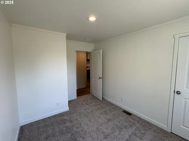 an empty room with closet and a ceiling fan