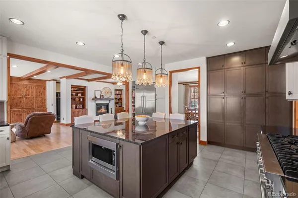 a kitchen with stainless steel appliances granite countertop a stove a refrigerator a oven a sink a island with a dining table and chairs