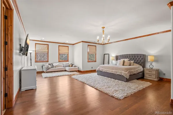 a spacious bedroom with a bed and a flat screen tv