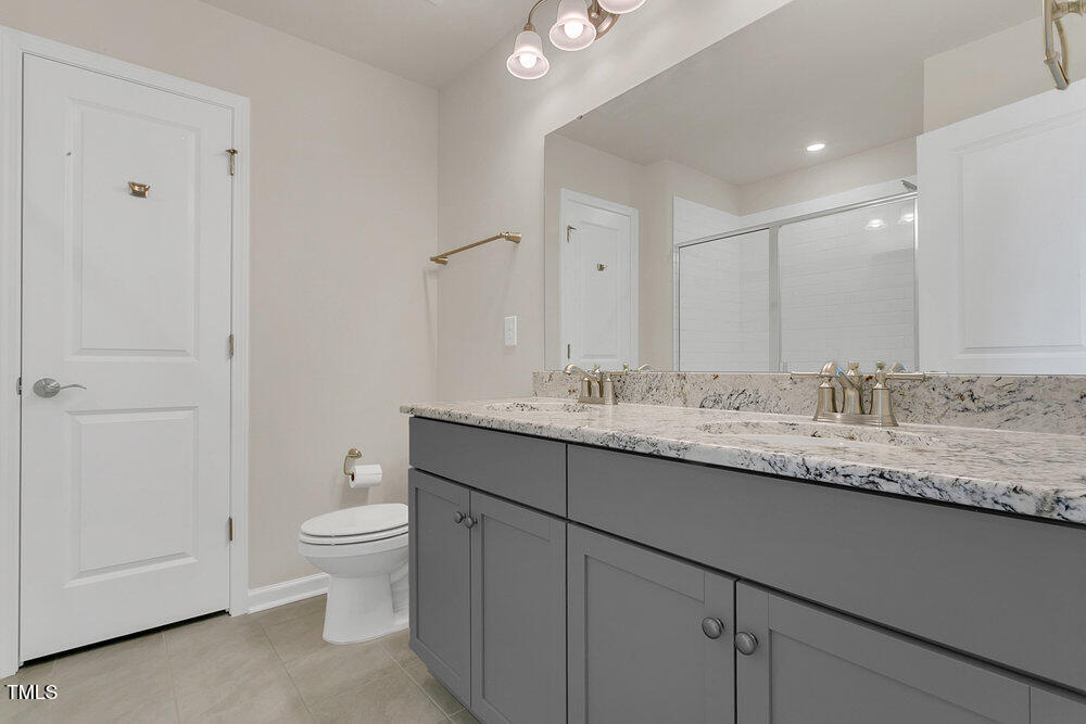 3512 Dragonfly River Raleigh, NC 27604 - Photo 21 of 37 a bathroom with a granite countertop sink a toilet and a mirror