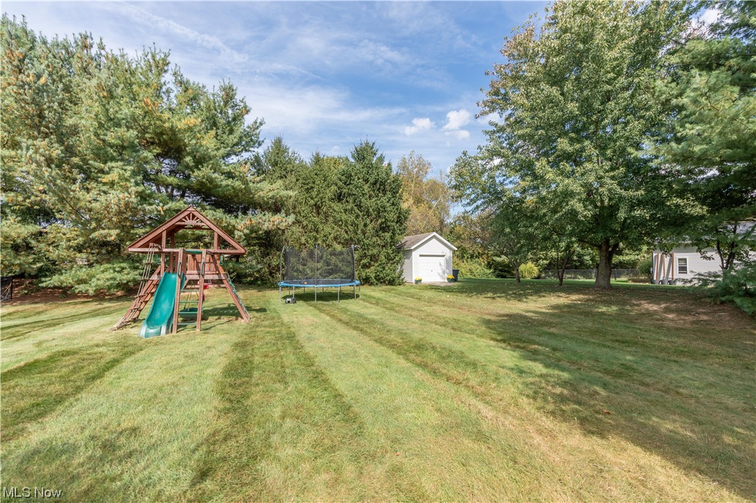 939 Pontius Road Mogadore, OH 44260 - Photo 31 of 35 View of yard with a playground, a trampoline, and a shed