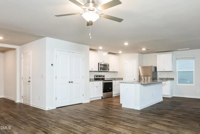 a open kitchen with a refrigerator and a stove top oven