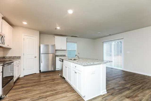 a kitchen with a stove a refrigerator and a sink