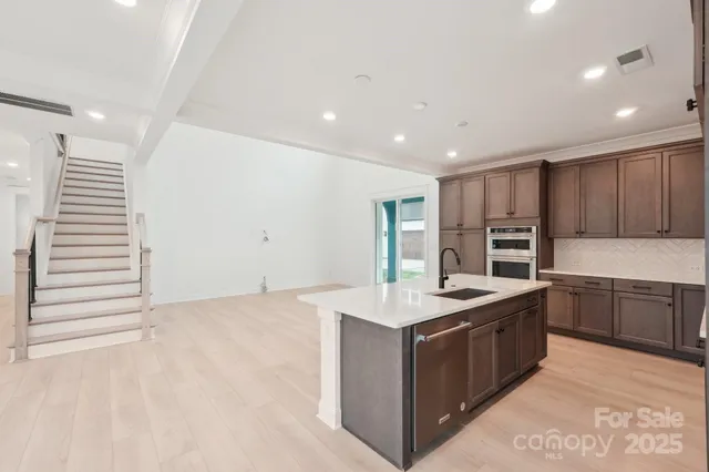 a kitchen with stainless steel appliances granite countertop a sink a stove and a refrigerator