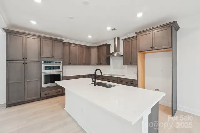 a kitchen with kitchen island a counter top space stainless steel appliances and cabinets