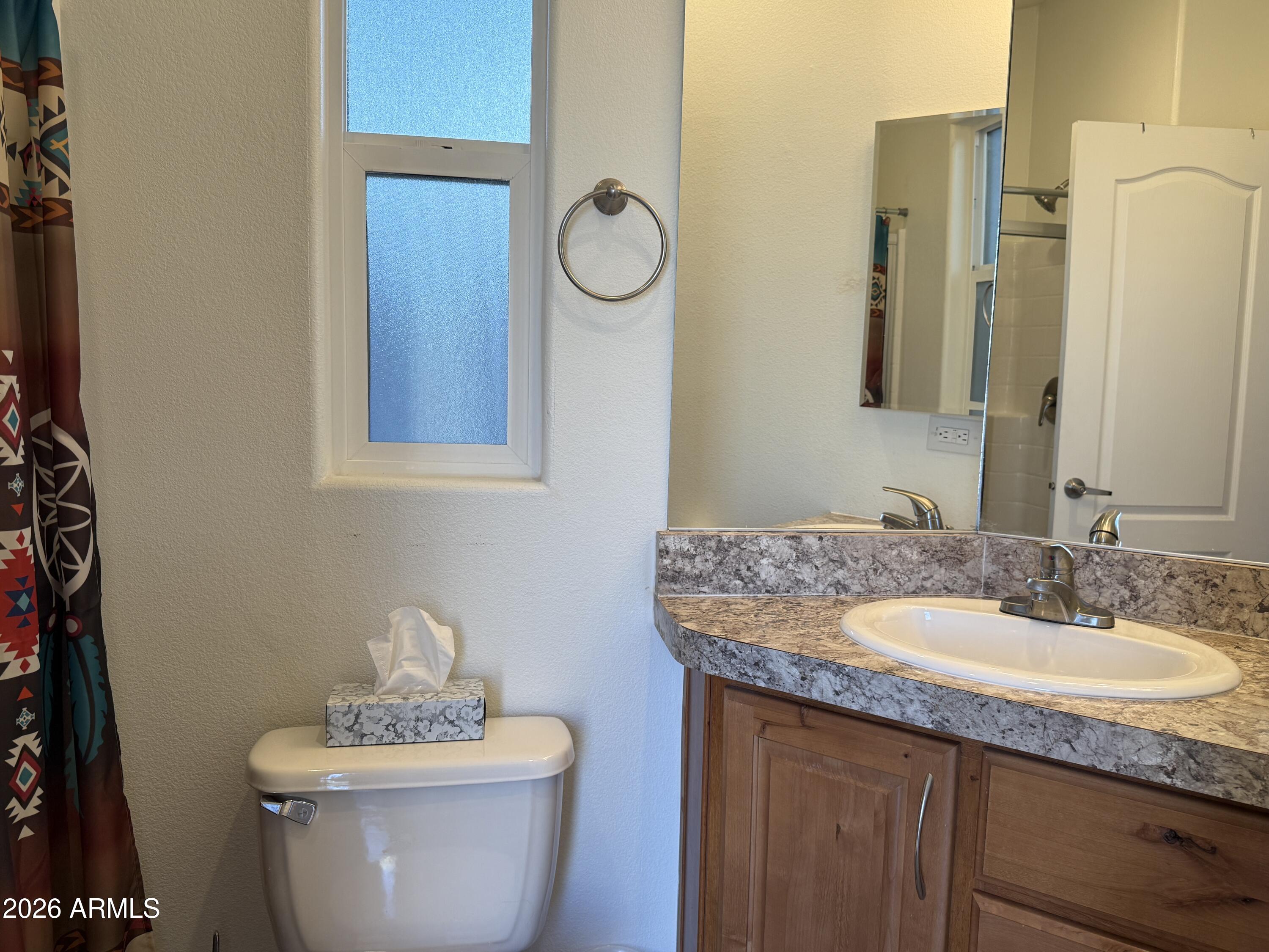 21245 Westward View Road, Unit 248 Congress, AZ 85332 - Photo 17 of 28 a bathroom with a granite countertop sink and a mirror