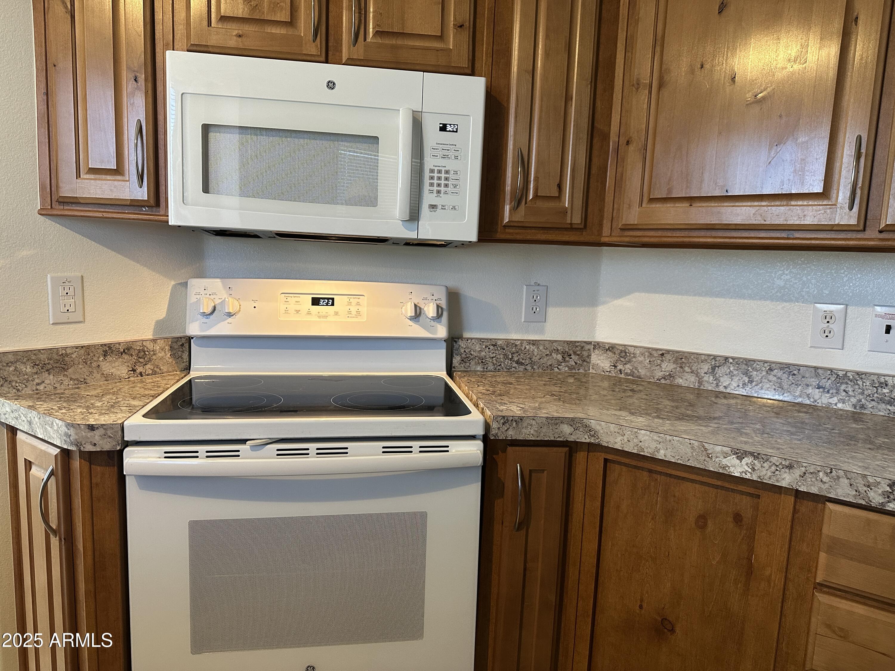 21245 Westward View Road, Unit 248 Congress, AZ 85332 - Photo 9 of 28 a kitchen with stainless steel appliances granite countertop a stove microwave and cabinets