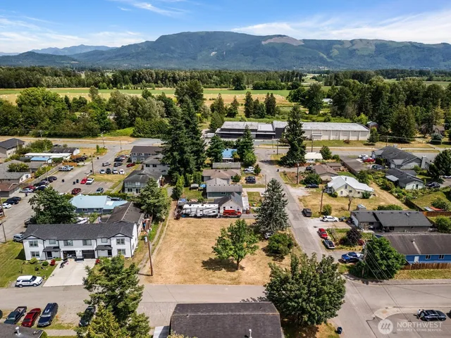 an aerial view of residential houses with outdoor space and mountain view