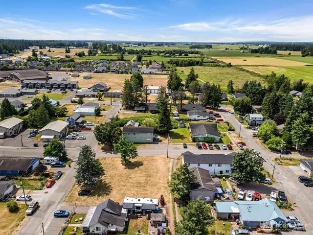 an aerial view of a city with lots of residential buildings ocean and mountain view in back