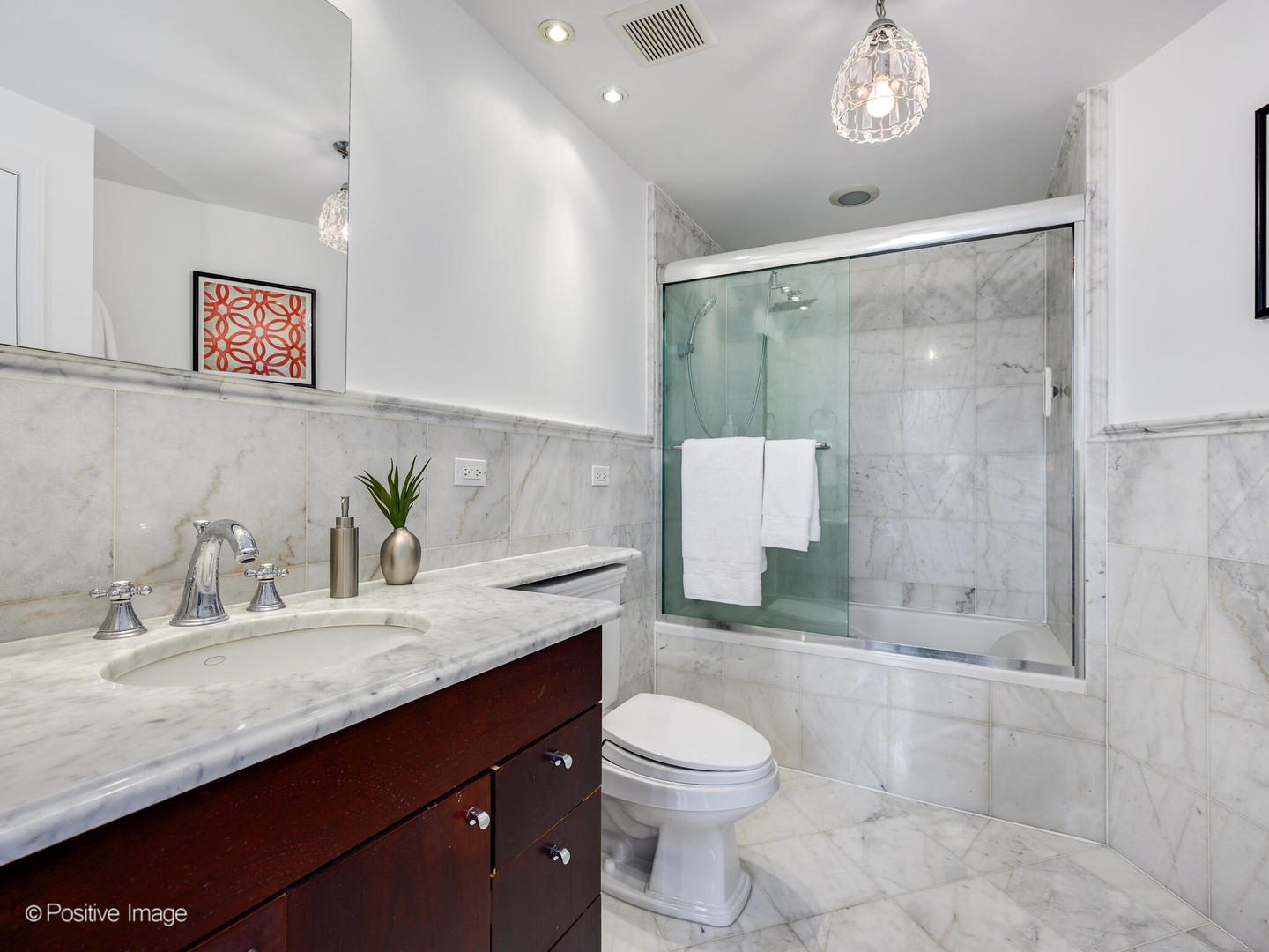 1019 West Jackson Boulevard, Unit 2B Chicago, IL 60607 - Photo 17 of 22 a bathroom with a granite countertop sink a toilet a mirror and shower