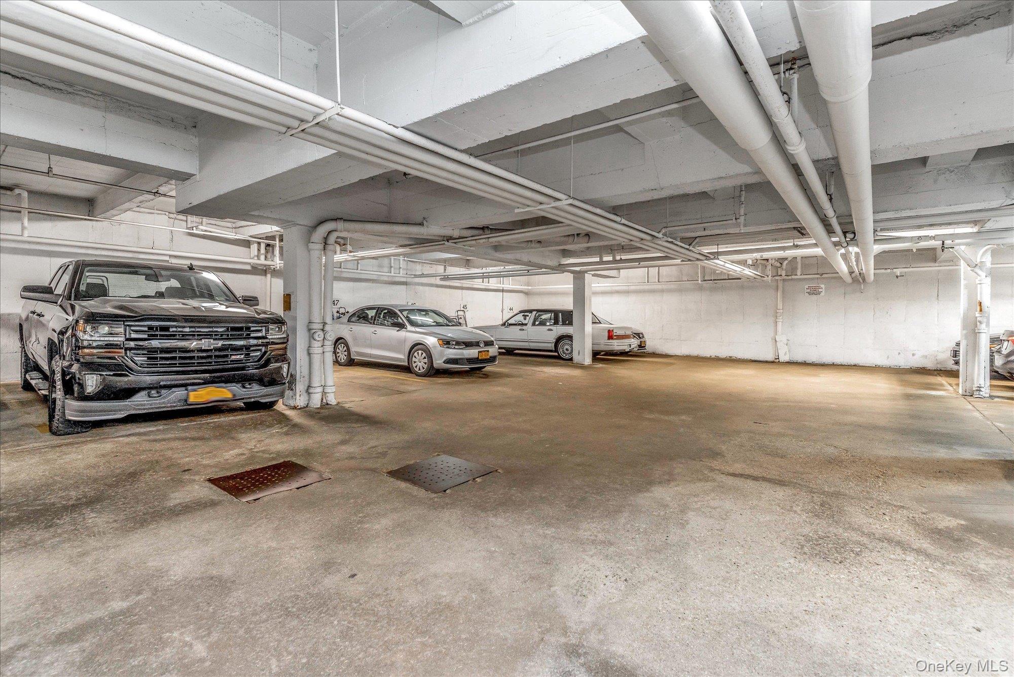 504 Merrick Road, Unit 4J Lynbrook, NY 11563 - Photo 21 of 28 a view of parking garage with cars